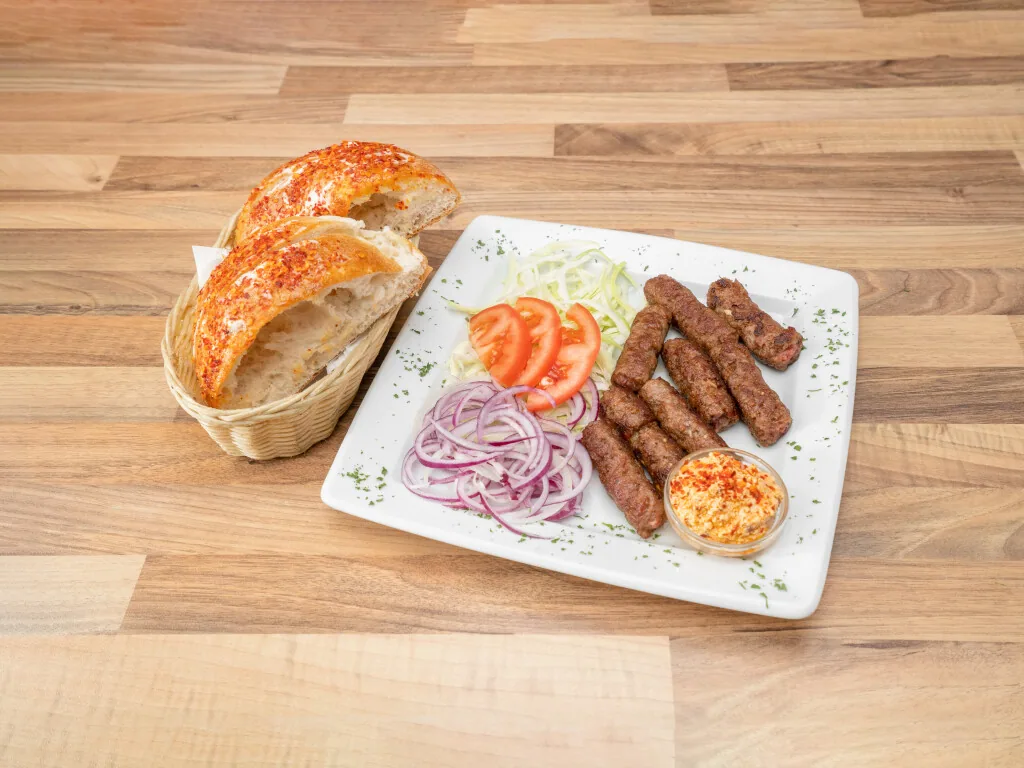 Cevapcici im Teller mit Beilagen
